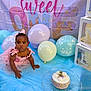 baby, girl, birthday, cake, balloons, pink_dress, headband, tutu, crawling, blue_sheet, number_1_candle, sweet_one_backdrop, celebration, party, cute, infant, portrait, decorations, blocks, happy
