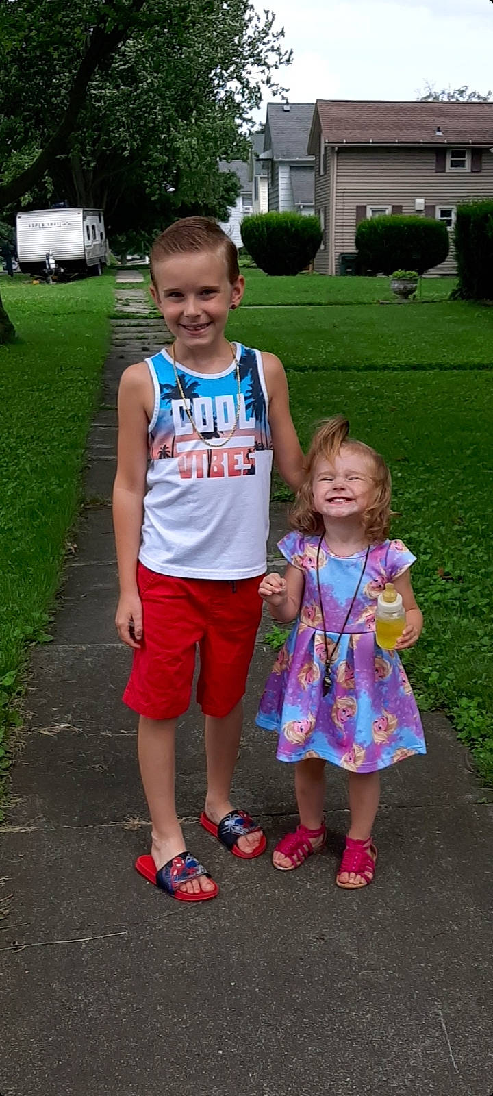 Kristian is registered to the contest to win money with this photo: clothing, face, fun, grass, hair, hairstyle, happy, head, joy, leisure, person, pink, plant, recreation, sandal, shorts, smile, sneakers, style, summer