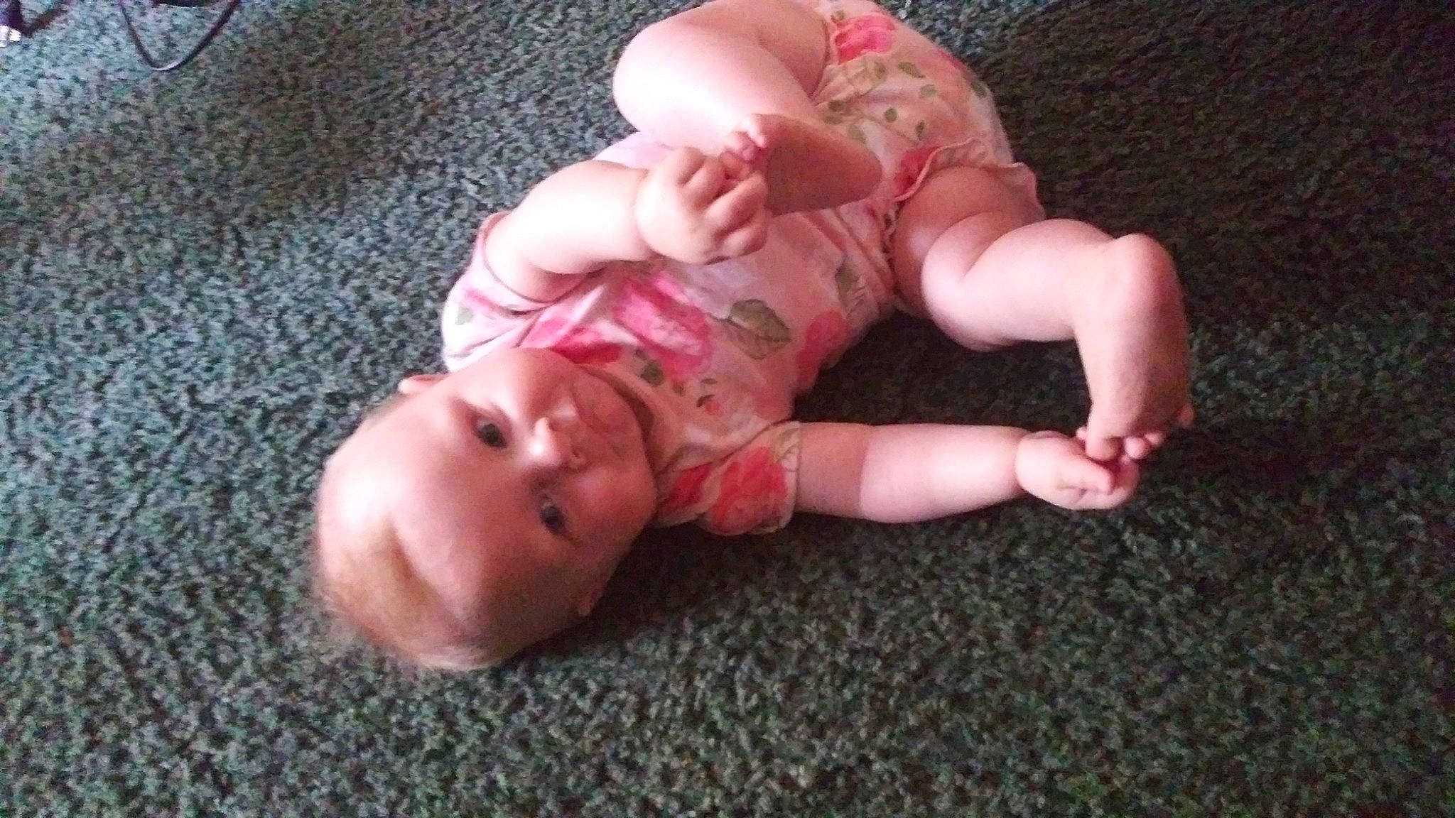 Saria is registered to the contest to win money with this photo: baby, baby_toddler_clothing, cheek, child, comfort, flesh, flooring, foot, grass, hand, hardwood, human_body, human_leg, nail, person, sitting, thumb, toddler, toy, wood