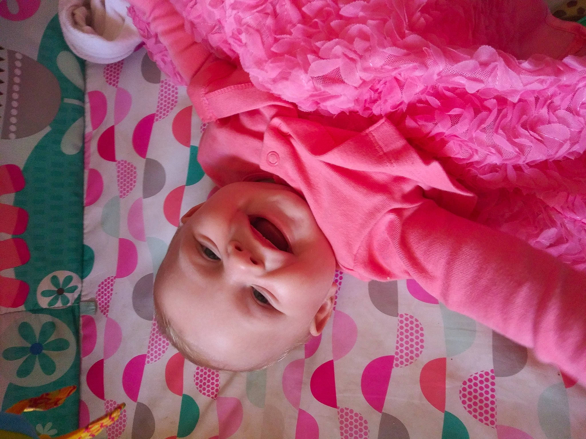 Saria is registered to the contest to win money with this photo: baby, baby_toddler_clothing, cheek, child, eyelash, happy, headgear, linens, lip, magenta, material_property, pattern, peach, person, petal, pink, skin, smile, sweetness, textile