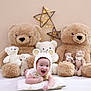 baby, infant, smiling, knitted_hat, bear_ears, pillow, teddy_bear, stuffed_animal, plush_toy, star_lights, decor, cute, happy, child, toy_collection, soft_toys, indoor, bed, blanket, portrait