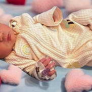 Esther is registered to the contest to win money with this photo: baby, newborn, sleeping, onesie, blanket, heart, soft, infant, cute, cozy, peaceful, child, bedtime, pattern, fabric, hand, face, lying_down, pink, red