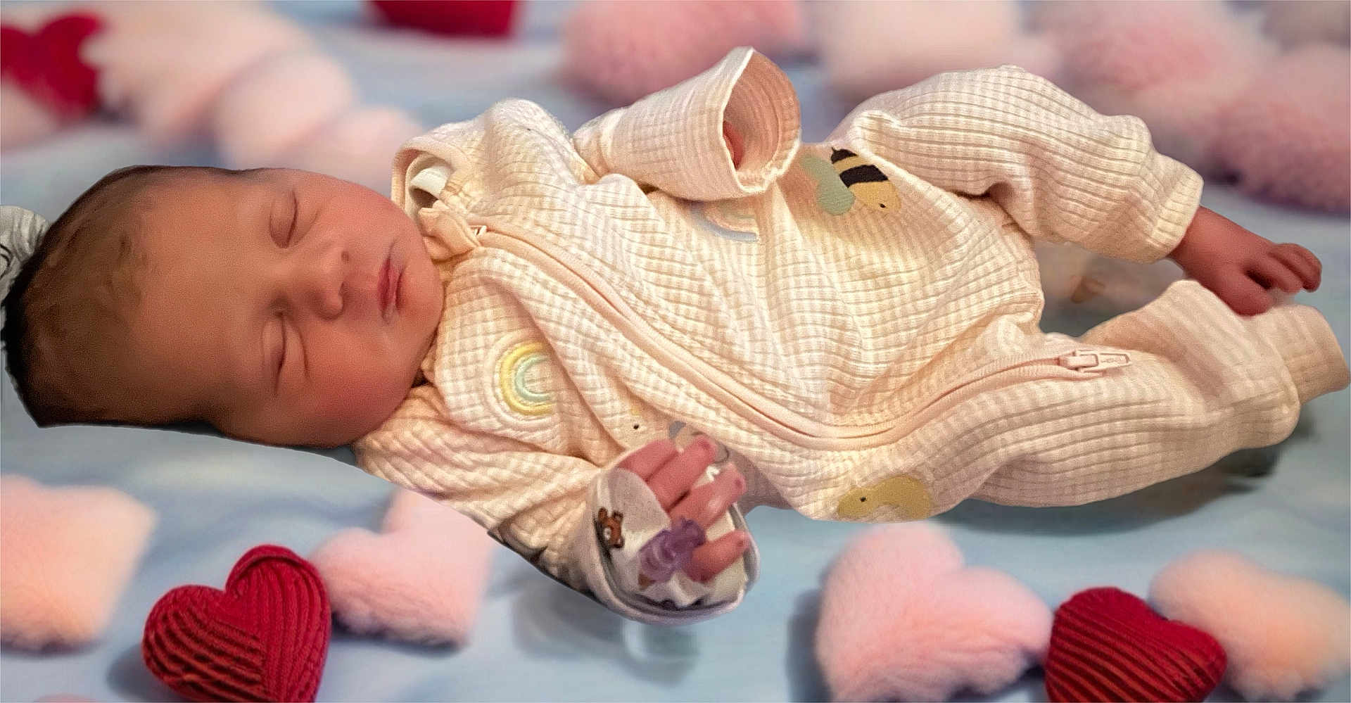 Esther is registered to the contest to win money with this photo: baby, newborn, sleeping, onesie, blanket, heart, soft, infant, cute, cozy, peaceful, child, bedtime, pattern, fabric, hand, face, lying_down, pink, red