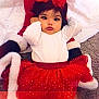 Remiyah is registered to the contest to win money with this photo: baby, big_eyes, blanket, bow, carpet, child, christmas, costume, cute, dark_hair, face, holiday, infant, lying_down, plush, portrait, red_dress, toddler, tutu, white_trim