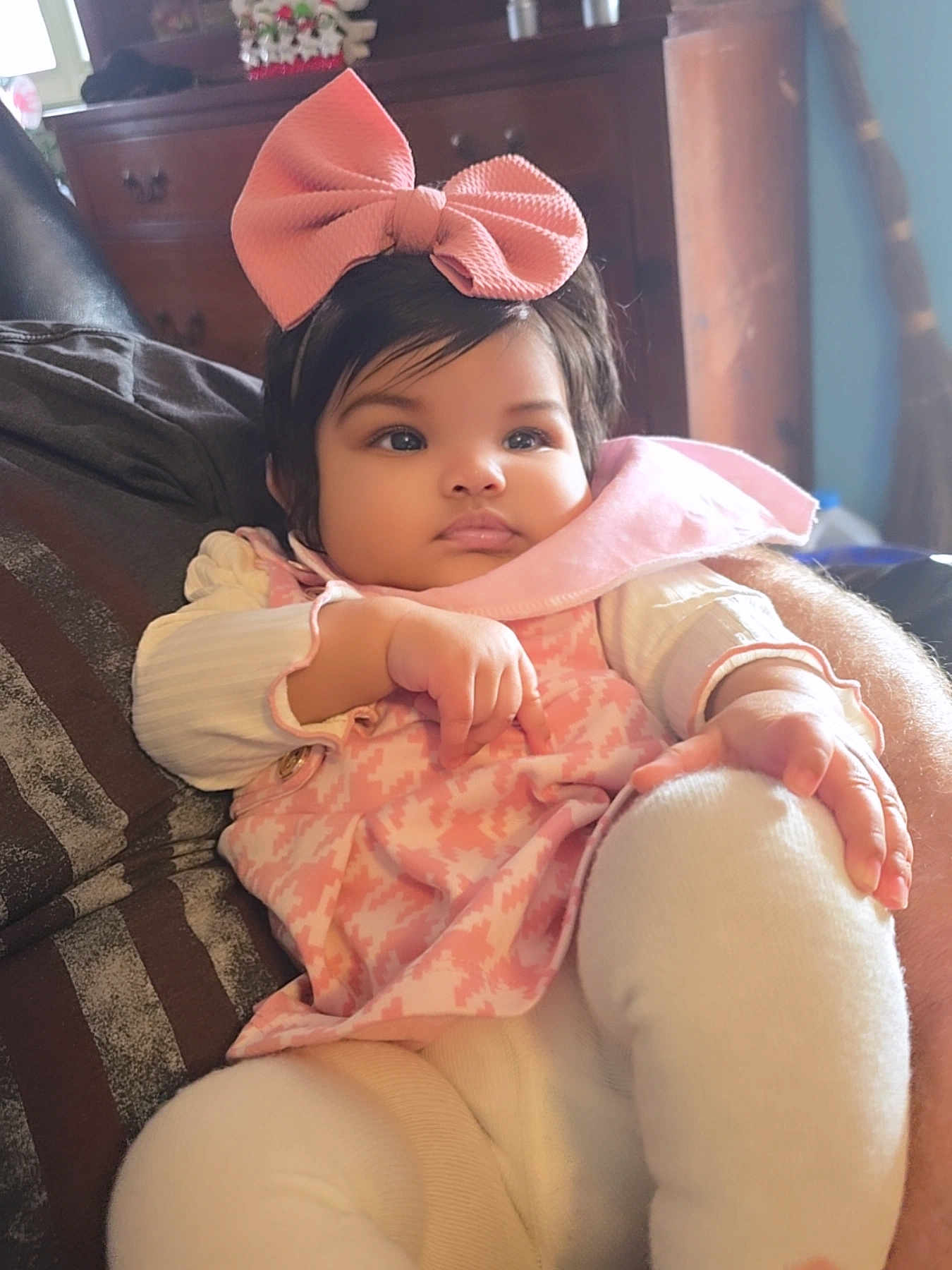 Remiyah is registered to the contest to win money with this photo: baby, infant, bow, headband, pink_bow, dress, pink_dress, bib, chubby_cheeks, big_eyes, face, hand, legs, sitting, couch, indoor, dresser, blanket, soft_lighting, portrait