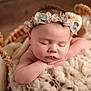 baby, sleeping, flower_crown, basket, blanket, soft_texture, infant, peaceful, portrait, newborn, cute, resting, cozy, closeup, head, skin, hands, indoor, warm_colors, child