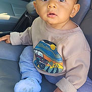 Hugo joined the competition — help win amazing prizes! baby, child, infant, car_seat, clothing, sweater, socks, curly_hair, big_eyes, portrait, indoor, seat, cute, casual, looking_up, person, young, human, sitting, expression