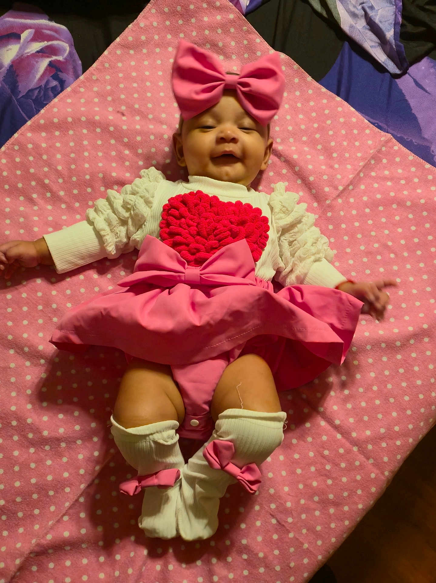 Izabella joined the competition — help win amazing prizes! baby, infant, child, pink_bow, polka_dot_blanket, dress, heart_applique, socks, leg_warmers, headband, smiling, happy, lying_down, blanket, clothing, portrait, nursery, feet, bow, soft_texture