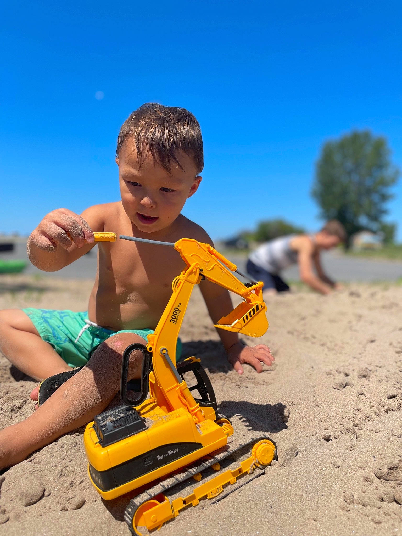 Castiel joined the competition — help win amazing prizes! body_of_water, fun, happy, landscape, leisure, outdoor_play_equipment, people_in_nature, person, recreation, sand, shorts, sitting, sky, soil, t_shirt, tire, toddler, toy, travel, tree
