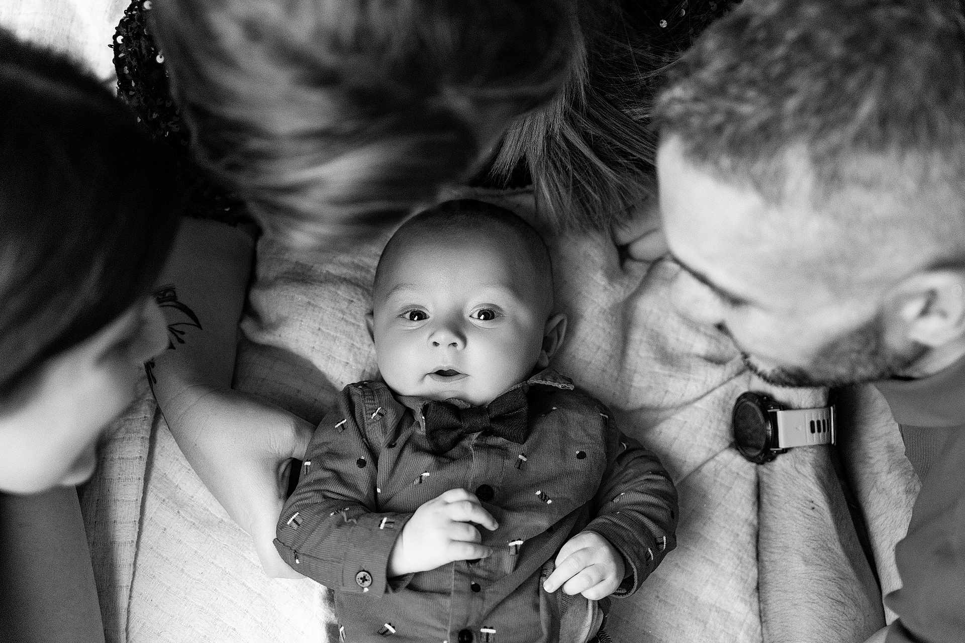Ezekiel participe au concours pour gagner de l'argent avec cette photo : baby, bow_tie, shirt, blanket, people, family, black_and_white, portrait, infant, hands, adult, watch, close_up, smiling, lying_down, cute, intimate, together, love, happy