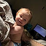 Gracen joined the competition — help win amazing prizes! baby, child, smiling, diaper, blanket, tattoo, arm, face, indoor, television, bed, candid, light, happy, person, skin, hair, expression, relaxed, cozy