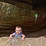 baby, child, rock, cave, smile, peeking, outdoor, nature, face, person, adventure, curious, stone, young, exploration, happy, hands, head, infant, casual