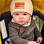 baby, child, beanie, hat, hoodie, stroller, hand, face, blue_eyes, serious_expression, yellow_canopy, outdoor, person, infant, clothing, portrait, cute, winter_wear, closeup, baby_grip