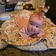 Ivy joined the competition — help win amazing prizes! baby, infant, blanket, toy, plush, floor, carpet, face, expression, indoors, child, person, clothing, head, cute, home, comfort, lying_down, looking, soft