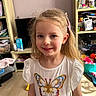 Ambre a rejoint le concours — aidez-le/la à gagner de superbes lots ! blonde_hair, bookshelf, butterfly_shirt, casual_clothing, child, colorful, cute, floor, furniture, girl, hair_clip, happy, home, indoor, light, person, portrait, smile, toys, young