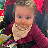 Cléo participe au concours pour gagner de l'argent avec cette photo : baby, bib, blue_eyes, child, clothing, colorful, curious, fabric, face, hair_clip, indoor, infant, messy_face, person, portrait, seatbelt, sitting, stroller, toy, young_child