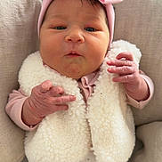 Emma participe au concours pour gagner de l'argent avec cette photo : baby, infant, newborn, pink_headband, bow, sherpa_vest, fluffy, hands, chubby_cheeks, face, eyes, pillow, cozy, cute, portrait, clothing, soft_texture, lying_down, small_hands, nursery