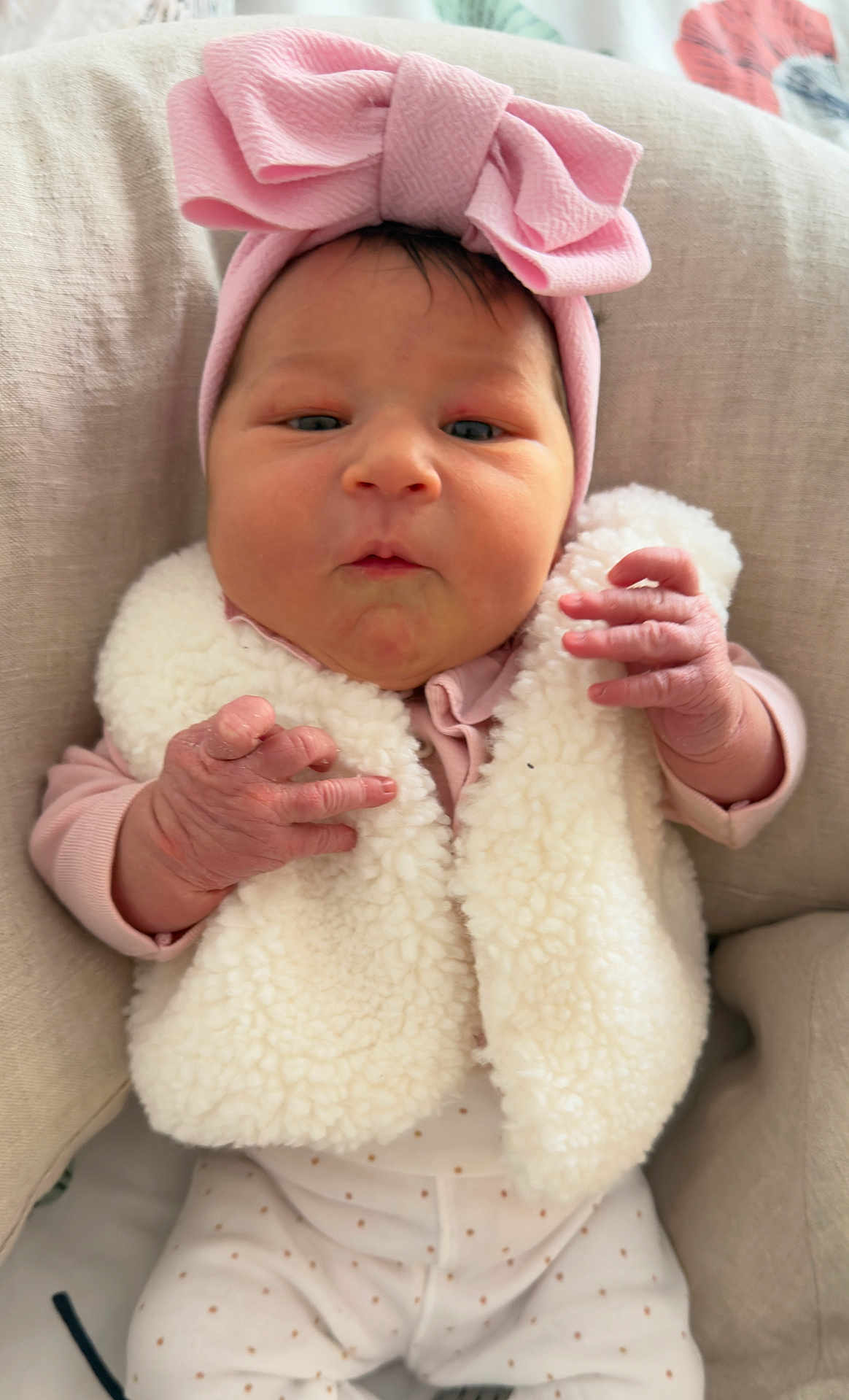 Emma participe au concours pour gagner de l'argent avec cette photo : baby, infant, newborn, pink_headband, bow, sherpa_vest, fluffy, hands, chubby_cheeks, face, eyes, pillow, cozy, cute, portrait, clothing, soft_texture, lying_down, small_hands, nursery