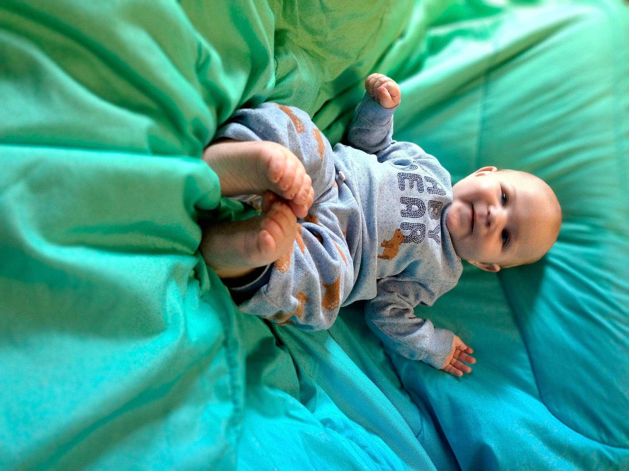 Chayse is registered to the contest to win money with this photo: baby, baby_products, baby_toddler_clothing, child, comfort, fun, gesture, grass, hand, happy, leisure, linens, person, sitting, smile, thumb, toddler, tree