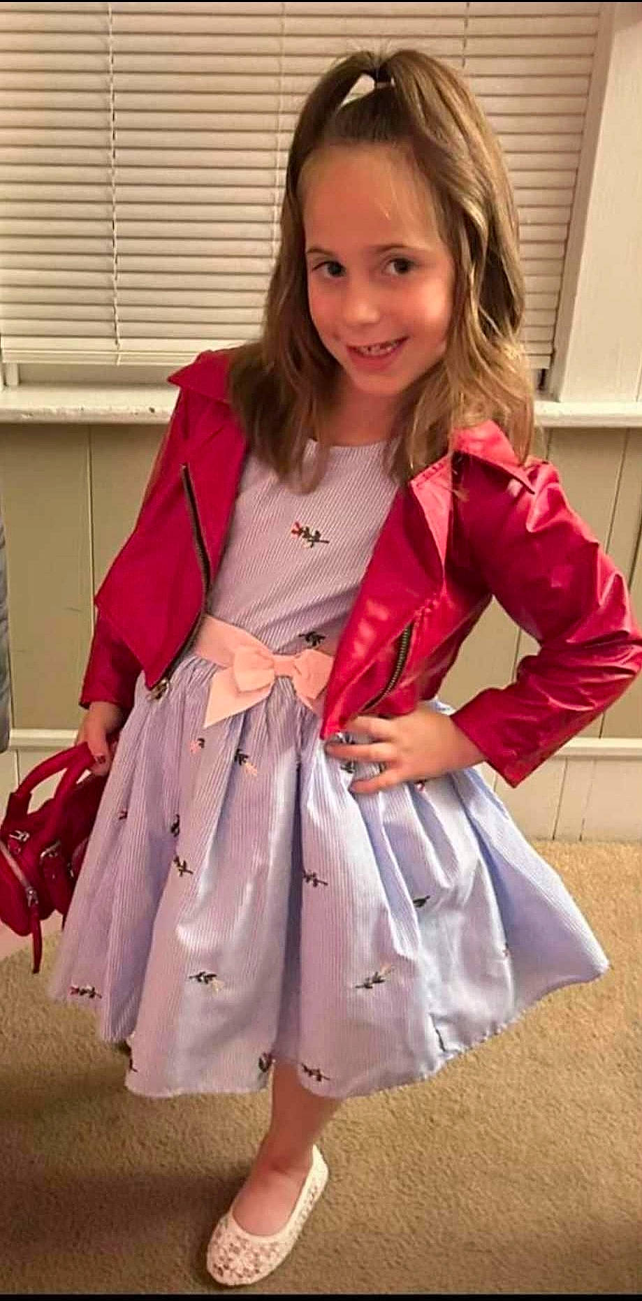 Makenzie is registered to the contest to win money with this photo: bag, blazer, clothing, collar, fashion_design, human_leg, joy, knee, long_hair, luggage_and_bags, magenta, outerwear, pattern, person, pink, sleeve, smile, textile, thigh, trunk