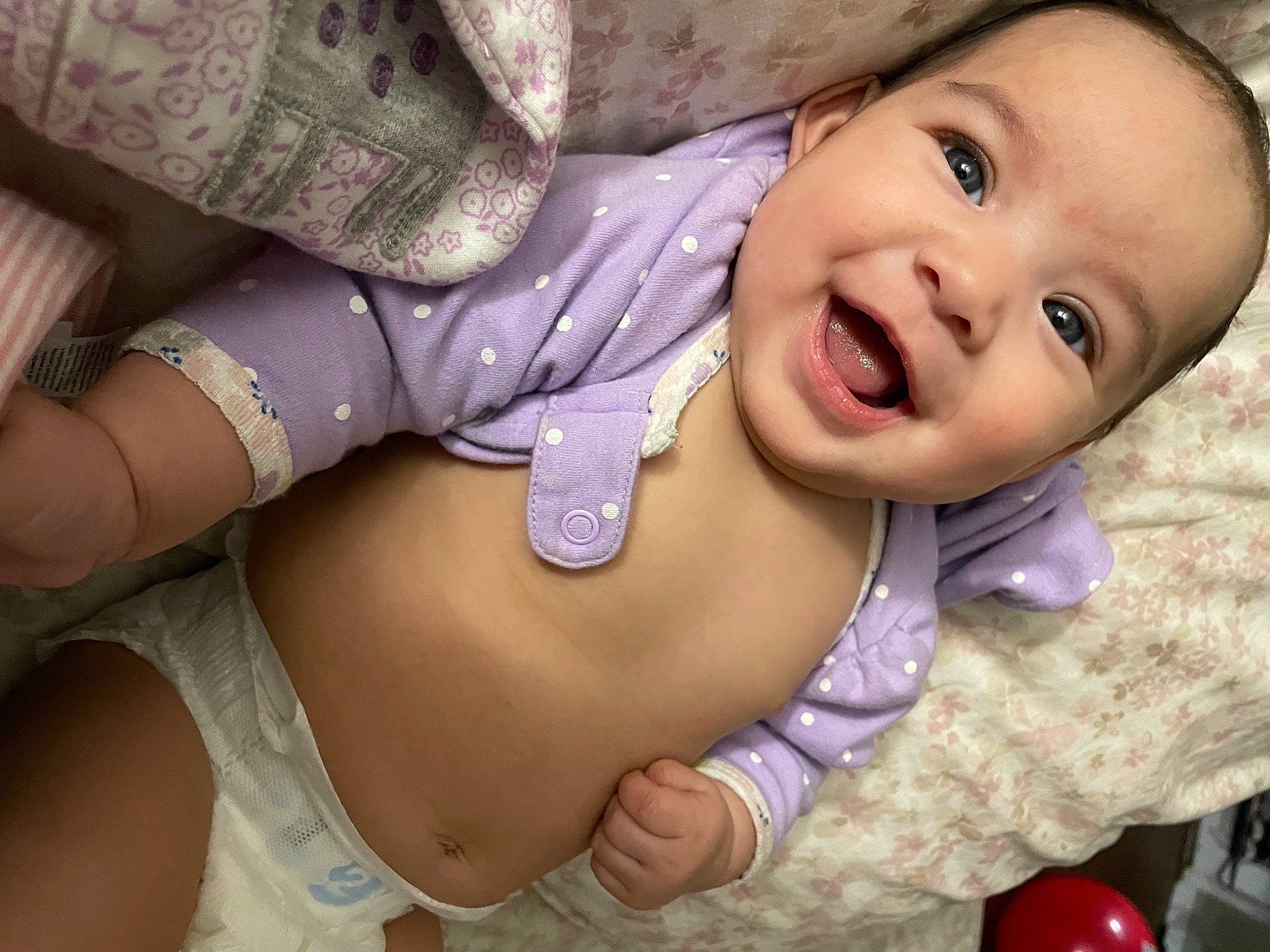 Brynn is registered to the contest to win money with this photo: arm, baby, baby_toddler_clothing, cheek, eye, eyelash, face, facial_expression, finger, gesture, happy, human_body, lip, mouth, neck, nose, person, pink, purple, skin