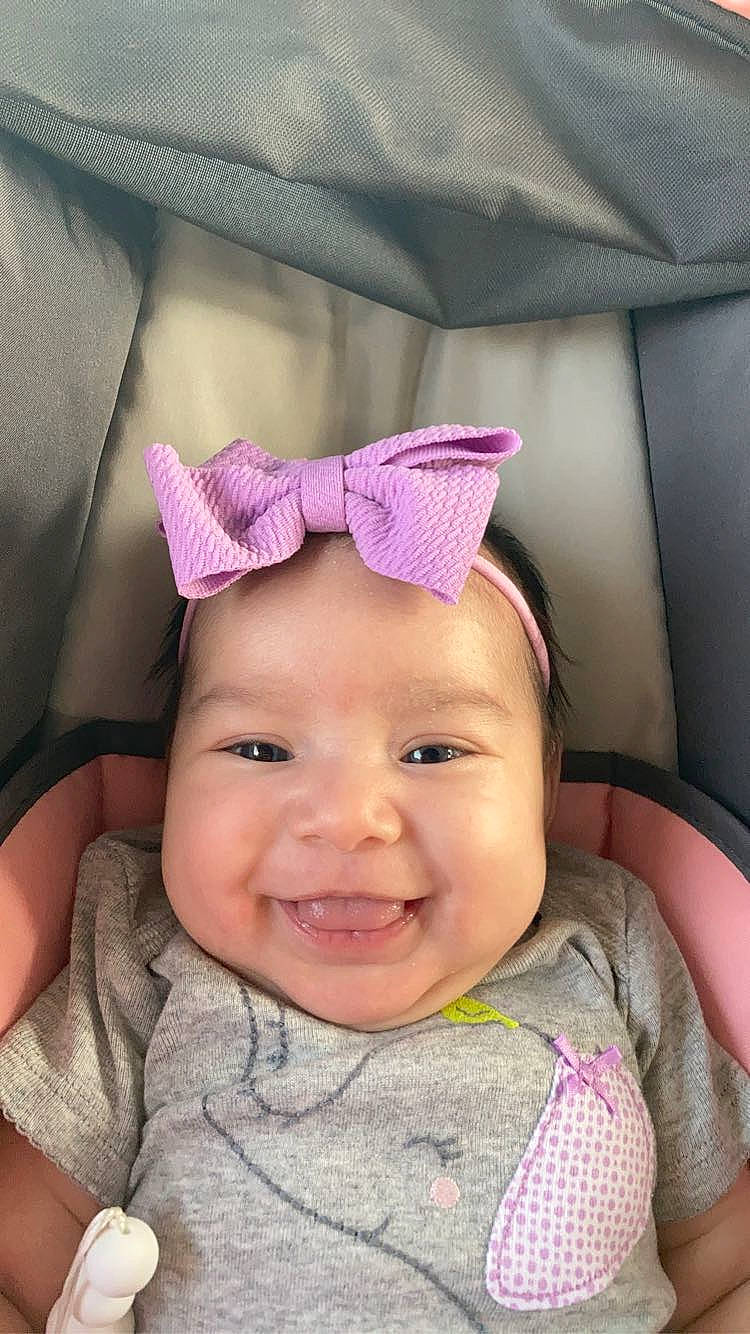 Brynn is registered to the contest to win money with this photo: baby, baby_toddler_clothing, cap, cheek, comfort, eyebrow, fashion_accessory, happy, head, headwear, joy, lip, magenta, person, photograph, pink, purple, sleeve, smile, textile