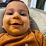 Marco participe au concours pour gagner de l'argent avec cette photo : baby, child, face, food, messy, smile, clothing, brown, text, indoor, cushion, seat, happy, infant, portrait, person, cute, closeup, home, young