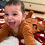 baby, child, smiling, crawling, brown_clothing, blanket, indoor, happy, face, person, furniture, dresser, home, cute, infant, joyful, closeup, expression, young_child, playful