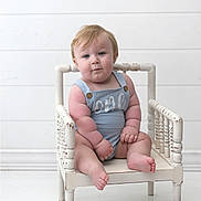 Rhett joined the competition — help win amazing prizes! baby, child, infant, blue_romper, white_chair, wooden_chair, sitting, portrait, cute, chubby, plump, indoor, minimalistic, white_background, expression, curious, hands, feet, blonde_hair, face