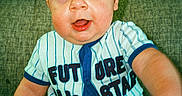Michael is registered to the contest to win money with this photo: baby, child, infant, couch, clothing, striped_shirt, onesie, socks, sitting, face, eyes, hand, cute, indoor, portrait, person, smiling, young_child, furniture, texture