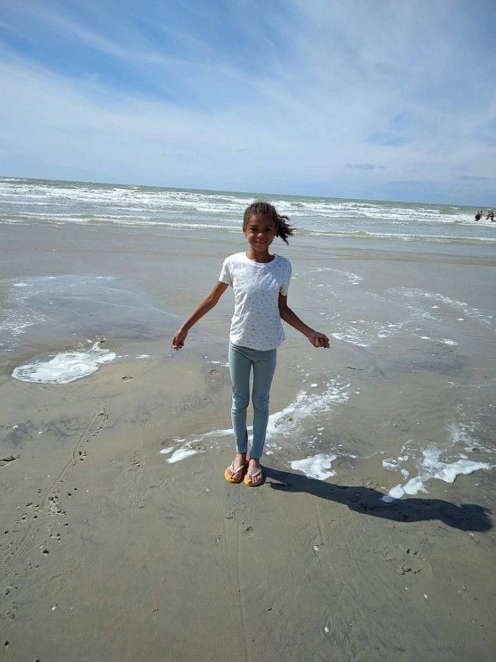 Kélya a rejoint le concours — aidez-le/la à gagner de superbes lots ! beach, calm, cloud, coast, coastal_and_oceanic_landforms, flash_photography, fun, gesture, happy, horizon, jeans, joy, people_in_nature, people_on_beach, person, sand, shore, sky, standing, water