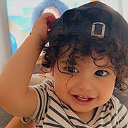 Ayane a rejoint le concours — aidez-le/la à gagner de superbes lots ! toddler, child, smiling, curly_hair, cap, striped_shirt, indoor, face, happy, person, portrait, cute, baby, hand, eyes, cheerful, young_child, headwear, couch, background