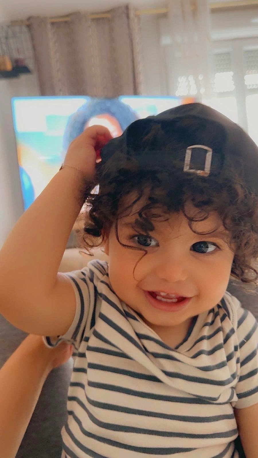 Ayane a rejoint le concours — aidez-le/la à gagner de superbes lots ! toddler, child, smiling, curly_hair, cap, striped_shirt, indoor, face, happy, person, portrait, cute, baby, hand, eyes, cheerful, young_child, headwear, couch, background
