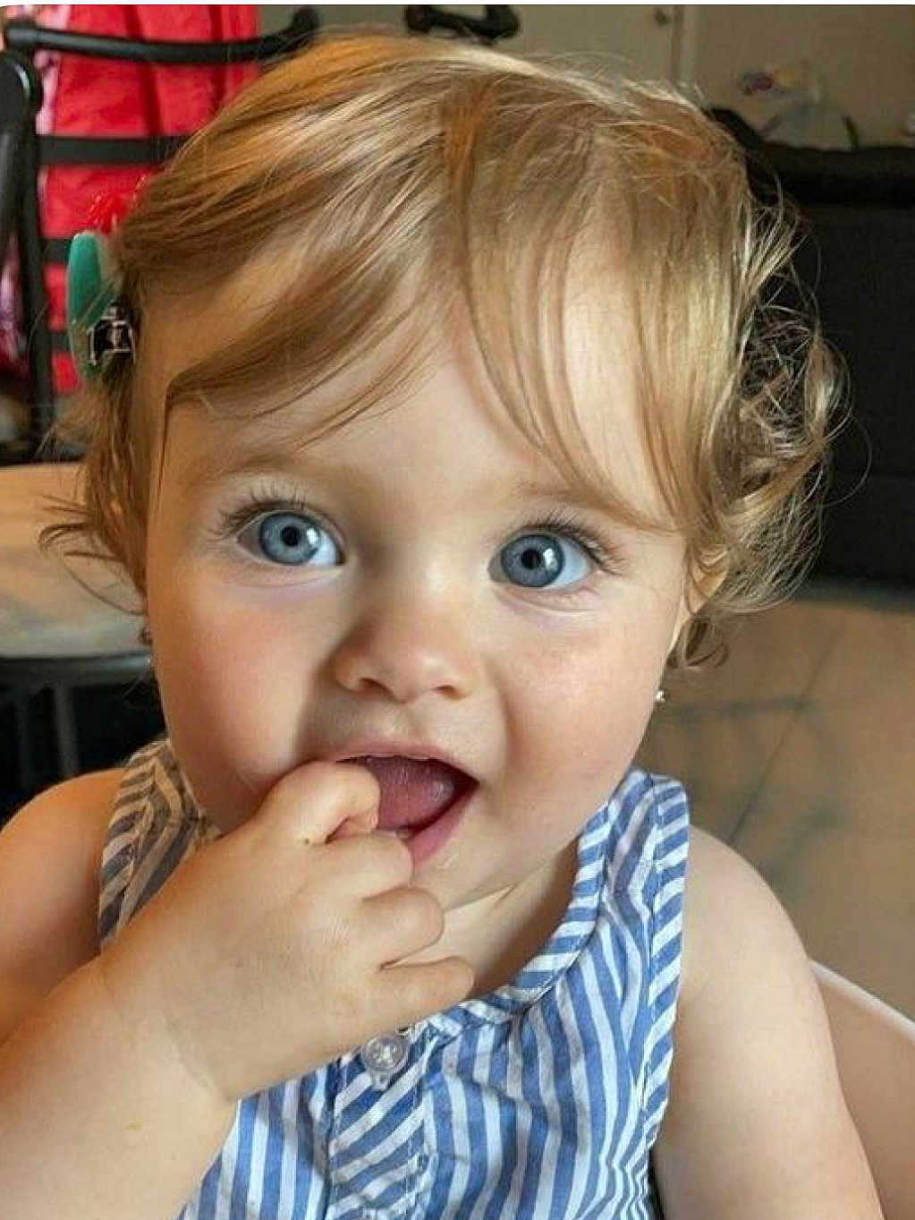 Louise participe au concours pour gagner de l'argent avec cette photo : baby, blond_hair, blue_eyes, child, close_up, curious, curly_hair, cute, expression, face, finger_in_mouth, hand, indoor, person, portrait, skin, sleeveless_top, striped_clothing, toddler, young_child