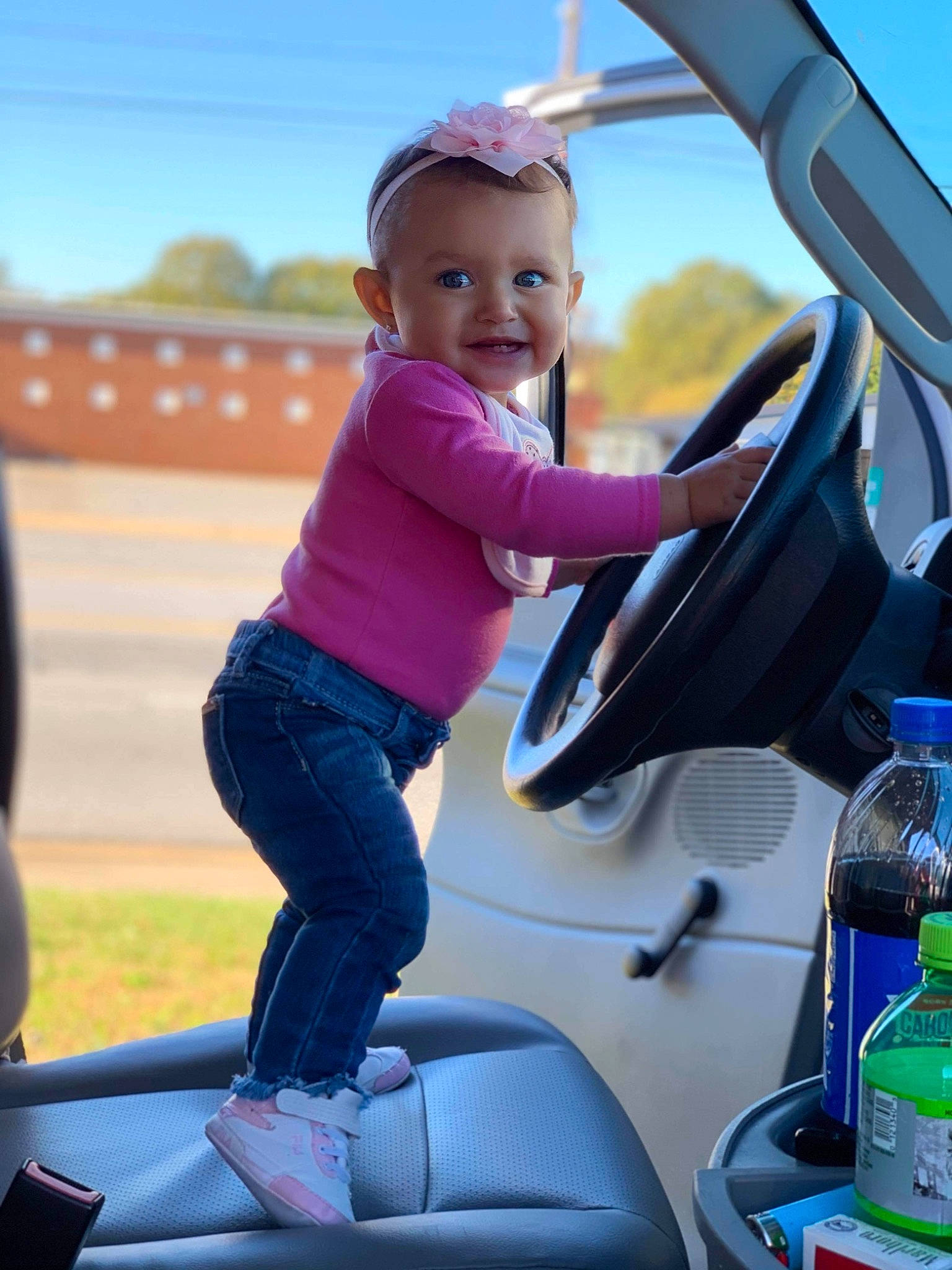 Makennah joined the competition — help win amazing prizes! automotive_exterior, automotive_mirror, automotive_window_part, baby, baby_toddler_clothing, blond, bottle, car_seat, car_seat_cover, child, child_model, glass, jeans, joy, person, plastic_bottle, play, steering_part, steering_wheel, toddler