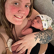 Mateo joined the competition — help win amazing prizes! woman, baby, tattoo, hat, smile, closeup, indoor, person, skin, hand, face, newborn, holding, caring, love, clothing, portrait, babywearing, happy, cute