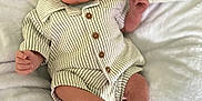 Mateo is registered to the contest to win money with this photo: baby, infant, newborn, one_month, milestone, striped_clothing, wooden_buttons, blanket, white_blanket, sign, clouds, curious, cute, lying_down, soft_texture, portrait, young_child, legs, hands, face