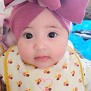 Khalia joined the competition — help win amazing prizes! baby, infant, face, headwear, pink_bow, bib, floral_pattern, cute, child, portrait, indoors, closeup, big_eyes, adorable, young_child, clothing, expression, skin, person, babywearing