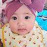 baby, infant, face, headwear, pink_bow, bib, floral_pattern, cute, child, portrait, indoors, closeup, big_eyes, adorable, young_child, clothing, expression, skin, person, babywearing