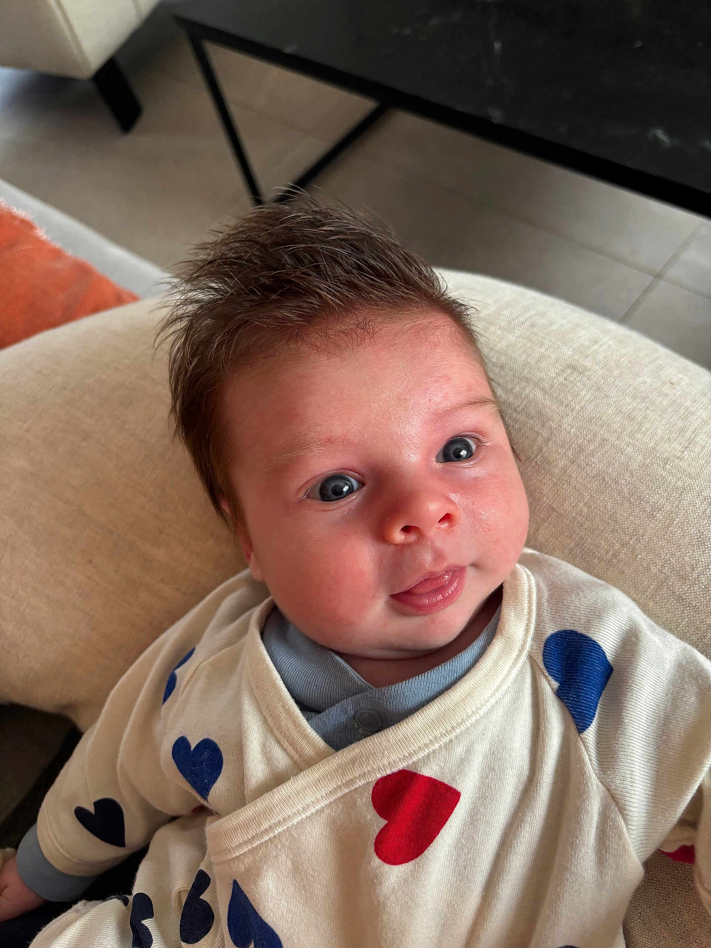 édouard a rejoint le concours — aidez-le/la à gagner de superbes lots ! baby, infant, face, blue_eyes, hair, clothing, heart_pattern, cushion, indoor, furniture, table, expression, cute, person, portrait, sitting, soft_light, skin, head, cozy