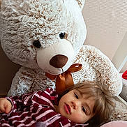 Freÿja participe au concours pour gagner de l'argent avec cette photo : child, teddy_bear, plush_toy, striped_pajamas, indoor, soft_texture, brown_ribbon, relaxed, cute, toy, cozy, portrait, young_child, bedroom, comfort, stuffed_animal, close_up, person, home, sleepwear