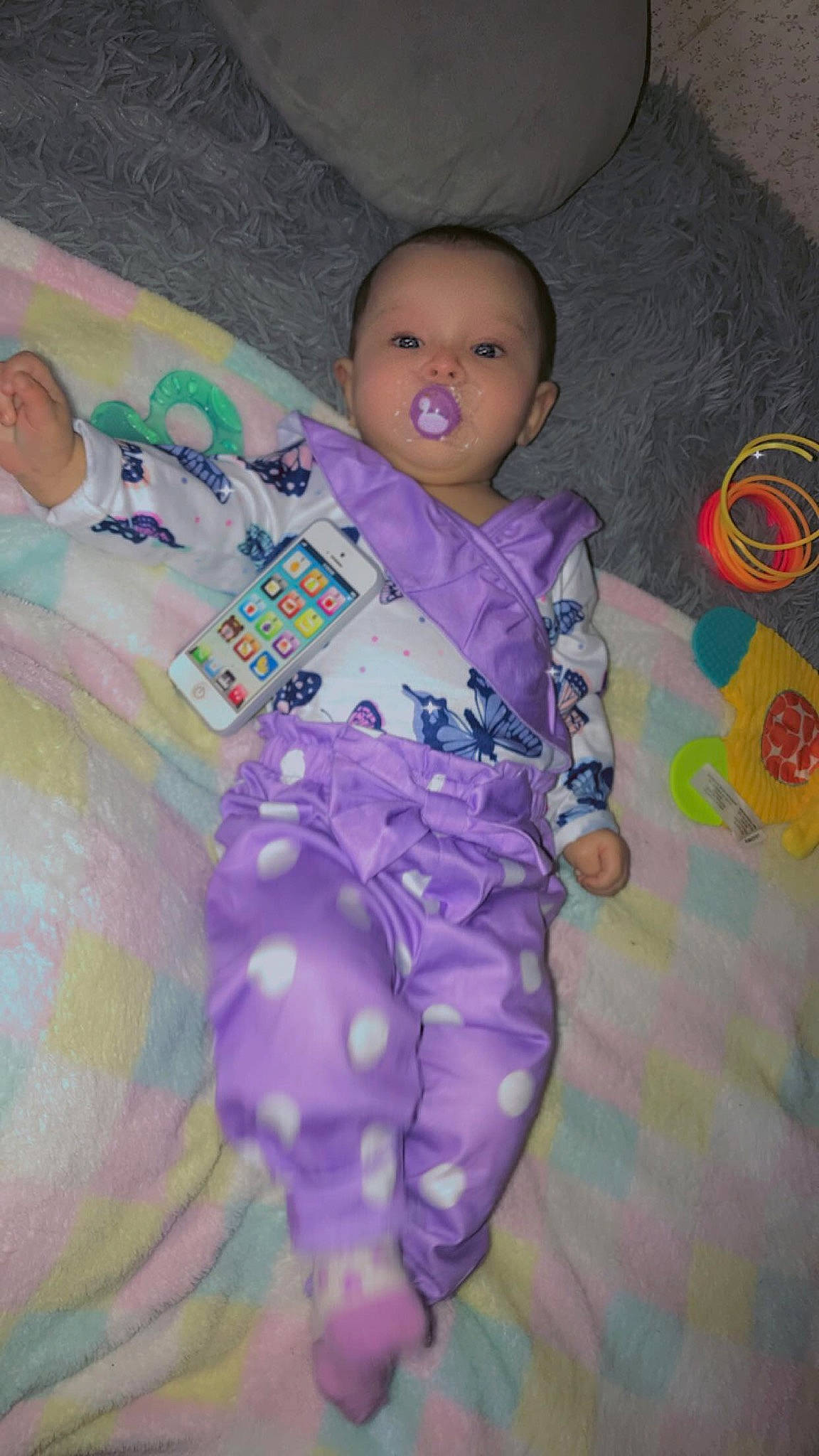 Karma is registered to the contest to win money with this photo: baby, baby_products, baby_toddler_clothing, cheek, child, comfort, facial_expression, fun, iris, linens, magenta, mouth, nose, person, pink, purple, room, skin, textile, toddler