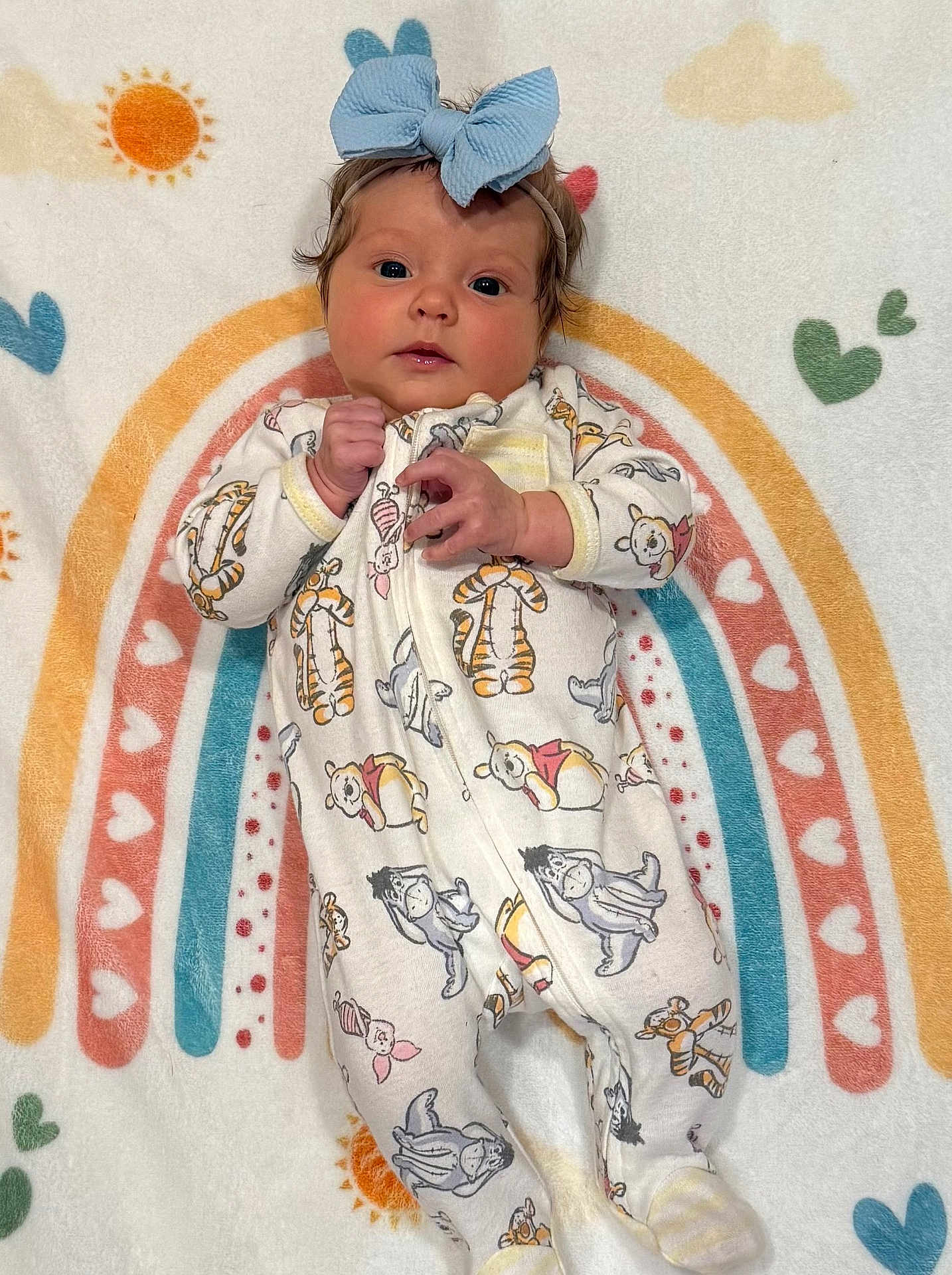 Conley joined the competition — help win amazing prizes! baby, infant, blue_bow, onesie, winnie_the_pooh, tigger, piglet, eeyore, rainbow, blanket, heart_pattern, sun_pattern, cute, child, lying_down, soft_texture, colorful, portrait, adorable, cozy