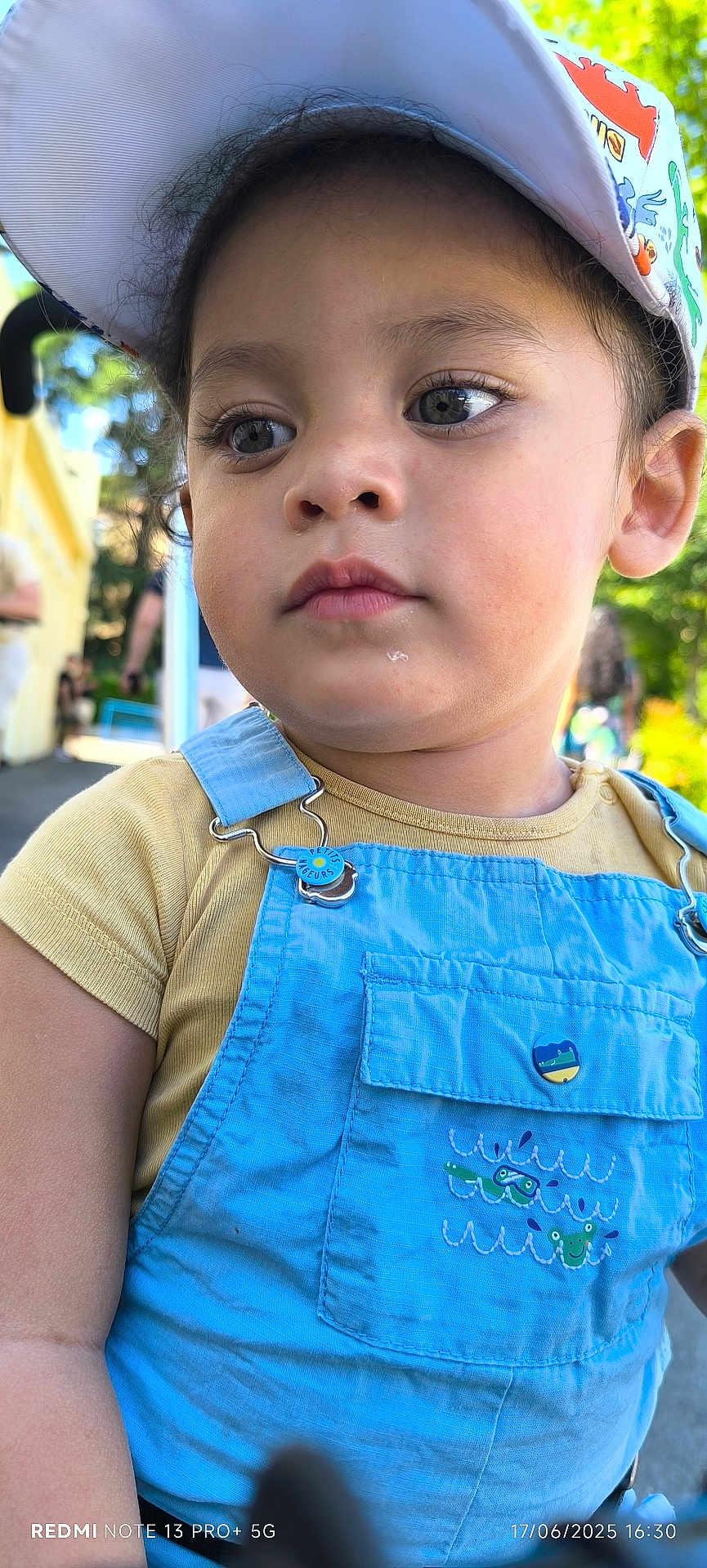 Jordan a rejoint le concours — aidez-le/la à gagner de superbes lots ! child, toddler, face, cap, hat, overalls, clothing, outdoor, portrait, young_child, casual_wear, daylight, curious, cute, person, baby, skin, expression, summer, nature