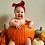 baby, pumpkin, red_bow, smiling, autumn, holiday, cute, child, orange, white_pumpkin, green_pumpkin, decor, festive, sitting, indoors, headwear, happy, skin, toes, hands
