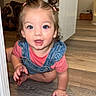 child, toddler, baby, girl, crawling, pigtails, hair_bows, blue_eyes, surprised, open_mouth, smiling, portrait, indoors, doorway, wood_floor, denim, overalls, pink_shirt, home, flash_photography