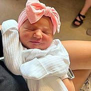 Hazel joined the competition — help win amazing prizes! baby, newborn, sleeping, pink_bow, headband, white_outfit, infant, person, arm, hand, skin, footwear, sandals, legs, indoors, soft_lighting, portrait, cozy, peaceful, closeup