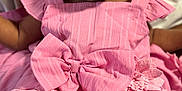 Brigette is registered to the contest to win money with this photo: baby, infant, child, pink_dress, bow, flower, clothing, portrait, face, eyes, skin, cute, adorable, sitting, young, person, indoors, fabric, soft, detail