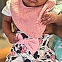 baby, infant, child, pink_bib, cow_pattern, bow, clothing, hands, face, eyes, person, cute, closeup, soft_light, indoor, fabric, pattern, holding, skin, portrait