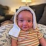 baby, infant, smile, striped_shirt, hat, knit, dinosaur_pattern, pillow, indoor, lamp, cozy, cute, child, portrait, seated, denim, happy, face, eyes, warm_lighting